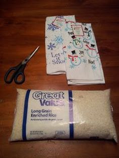 a pair of scissors sitting next to two flour bags and a bag of rice on a wooden table