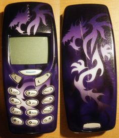 two cell phones with designs on them sitting next to each other, one is purple and the other is white