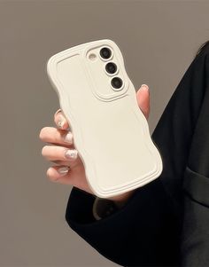 a woman holding a white cell phone case in her right hand with two black buttons on the back