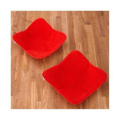 two red chairs sitting on top of a wooden floor