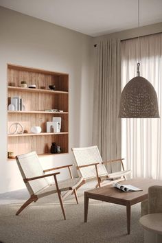 a living room with two chairs and a coffee table in front of a bookshelf