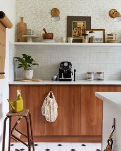 a kitchen with wooden cabinets and white tile flooring is pictured in this image, there are various items on the shelves above the counter