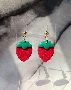 These strawberry earrings were made by hand using red and green polymer clay. They are perfect to wear during the summer or anytime of the year.  They are very lightweight and comfortable. Gold colored stainless steel ball posts. Lead and nickel free. Size - 1.25" Each piece is handmade and sanded. There may be small imperfections and no two are exactly alike. You may receive the earrings pictured or a similar pair. Playful Handmade Red Jewelry, Handmade Fun Red Earrings, Playful Red Earrings For Pierced Ears, Fun Red Adjustable Earrings, Strawberry Clay Earrings, Fun Red Resin Jewelry, Playful Handmade Red Earrings, Fun Green Polymer Clay Jewelry, Strawberry Earrings