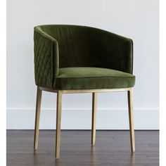 a green chair sitting on top of a hard wood floor next to a white wall