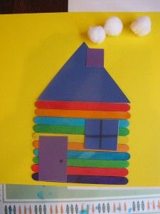 a house made out of popsicle sticks on top of a piece of construction paper