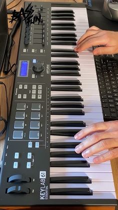 a person playing an electronic keyboard on a desk