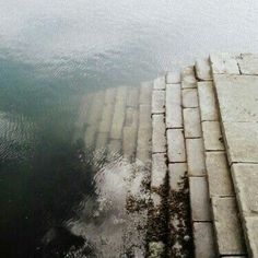 an old photo of some water and bricks