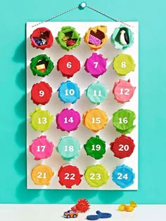 a colorful wall hanging with numbers on it and toys in front of the frame,