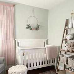 a baby's room with a white crib and pink curtains