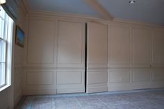 an empty room with white paneling on the walls