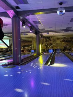 a bowling alley with blue and purple lights