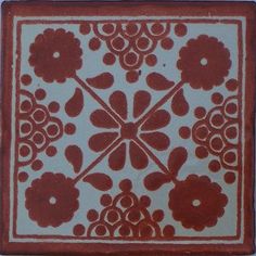 a red and white tile with flower designs on it's sides, in the center