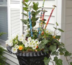 a potted plant with beads and flowers in it on the side of a house