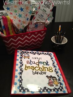 a desk with some books and pens in it on top of a black table next to a cup full of pencils