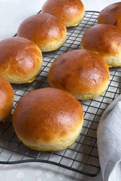 six buns on a cooling rack ready to go into the oven, with a cloth next to them