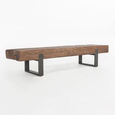 a wooden bench sitting on top of a white floor next to a black metal frame