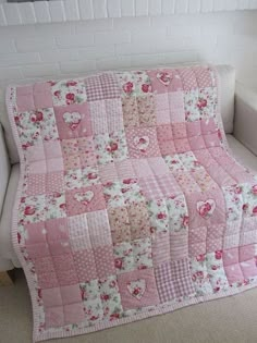 a white couch with a pink quilt on it