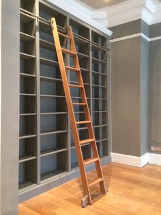 a ladder leaning up against a bookcase in an empty room