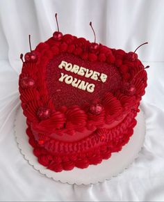 a red heart shaped cake with writing on it