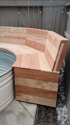 a wooden bench sitting next to a metal tub