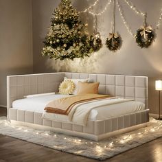 a white bed sitting in a bedroom next to a wall with christmas wreaths on it