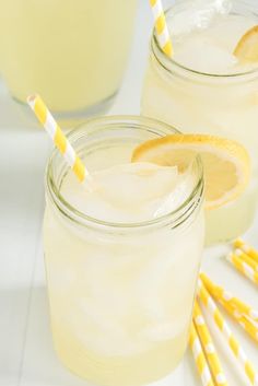 two mason jars filled with lemonade and drinking straws