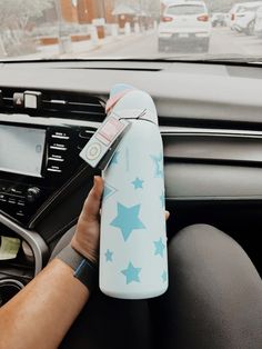 a person is holding a water bottle in their car