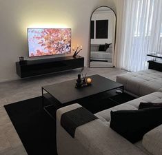 a living room filled with furniture and a flat screen tv on top of a wall