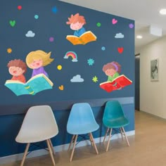 the children's room is decorated with colorful wall decals and chairs in front of it