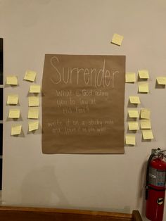 a bulletin board with sticky notes attached to it next to a fire extinguisher