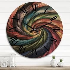 a large clock on the wall with an abstract swirl design in it's center