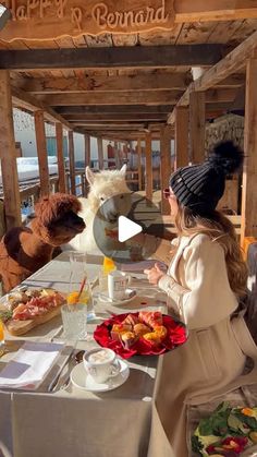 two women sitting at a table with stuffed animals