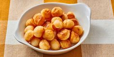 a white bowl filled with fried food sitting on top of a checkered table cloth