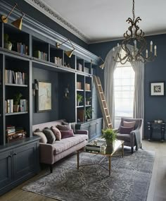 a living room with bookshelves, couches and a ladder in the corner