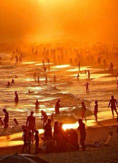 many people are on the beach at sunset