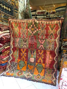 a pile of colorful rugs on display in a store