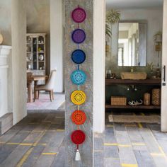 a wall hanging with seven colorful circles on it's side and a tassel in the middle