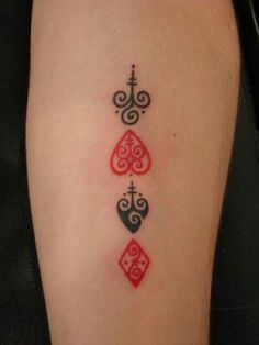 a woman's lower leg with three hearts and a cross tattoo on the side