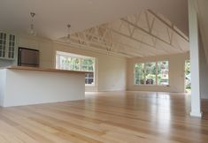 an empty living room with hard wood flooring and white walls, large open space