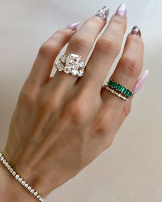 a woman's hand with two rings on her fingers and one ring in the middle