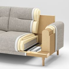 a couch that is sitting on top of a wooden table with an open drawer underneath it