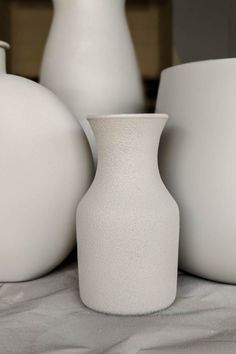 several white vases sitting on top of a table