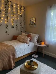 a bed room with a neatly made bed and some lights on the wall above it