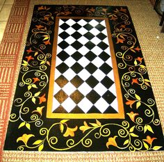 a black and white checkered floor with gold trimmings on the border, in front of a patterned area rug