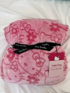 two pink hello kitty blankets on a white sheet