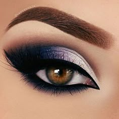 a close up shot of an eye with long lashes and purple eyeshadow on top