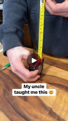 someone is measuring the height of a wooden table with a tape measure and pencils