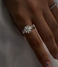 a woman's hand with two rings on her fingers and one ring in the middle