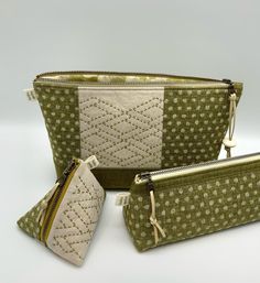 three green and white purses sitting next to each other