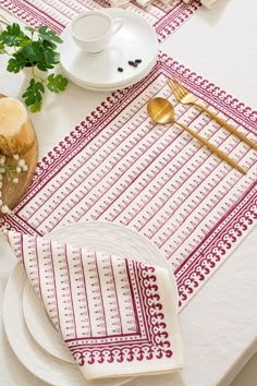 a white table topped with plates and silverware